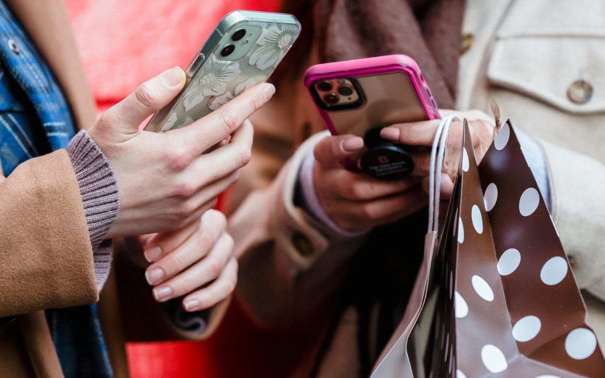 Group of friends using Upswap app on their phones while shopping together.