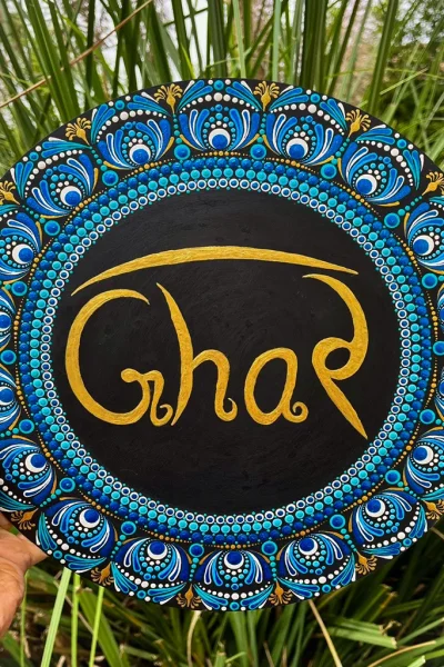 Dot Mandala Ghar Plate showcases the ancient art of dot painting, a technique that requires immense precision and creativity. Each dot is meticulously painted by hand to create stunning mandala patterns that radiate harmony and positivity. The vibrant blue, gold, and white tones are perfectly balanced, giving the plate an elegant yet lively appearance. At the center, the word “Ghar” (meaning “Home” in Hindi) is written in graceful gold lettering, making it a heartwarming symbol of love and belonging.