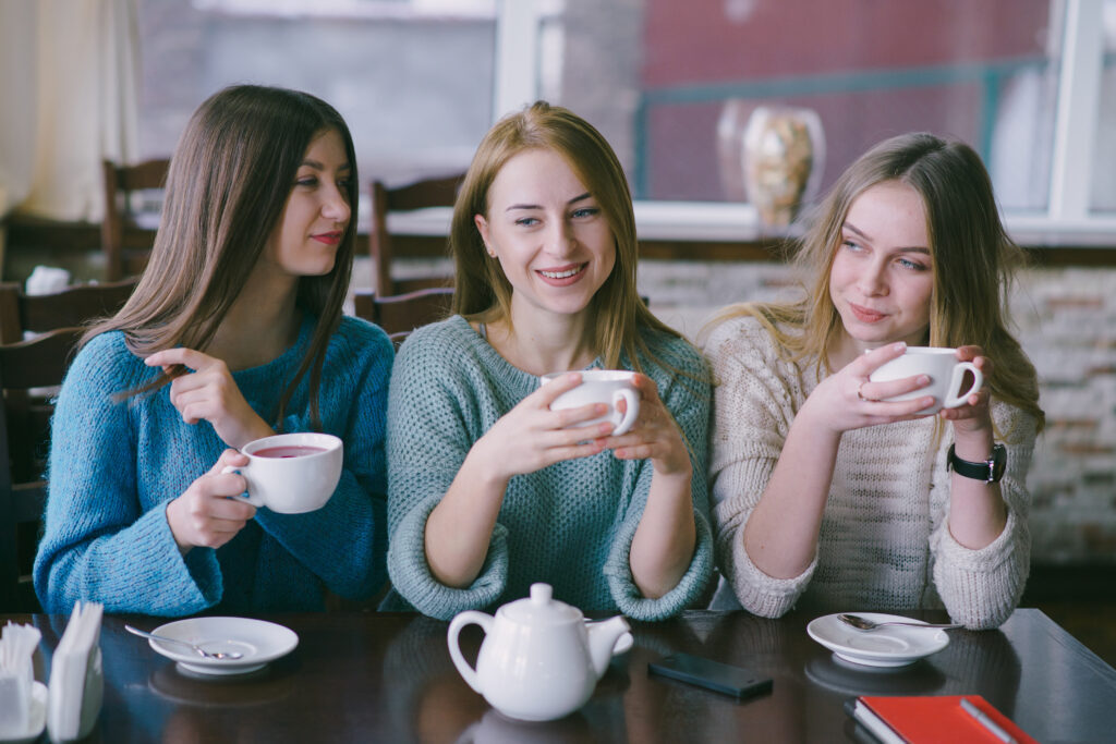 Group of friends laughing and chatting over chai cups