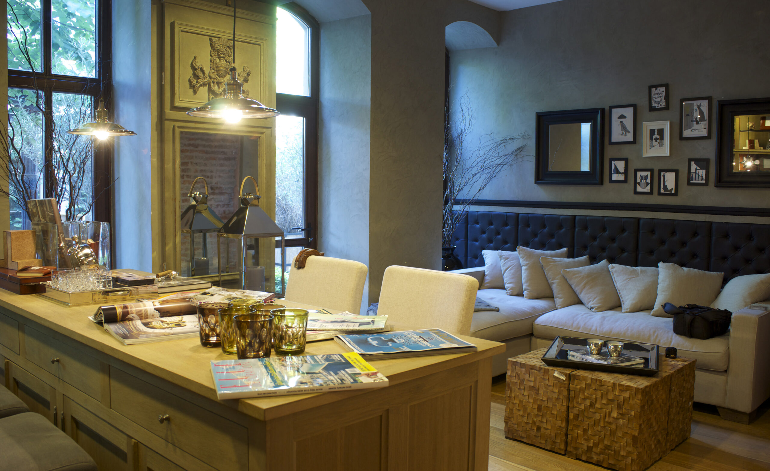  A cozy living room decorated with colorful Indian textiles, metallic lamps, and a large mirror.