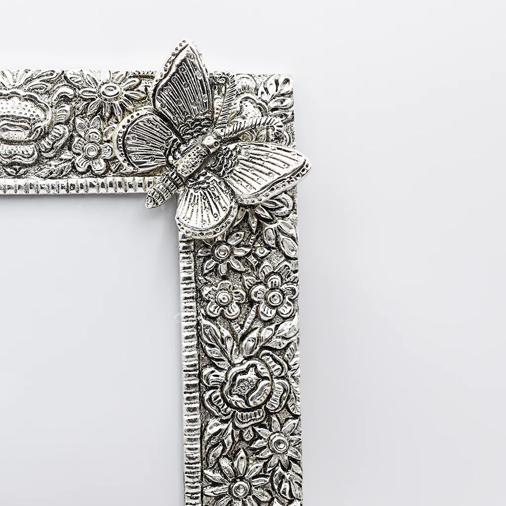 A silver photo frame with a butterfly design, showcasing intricate craftsmanship.