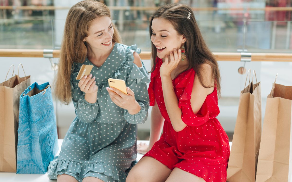 Girl using Upswap app on her phone to save money while shopping with friends.