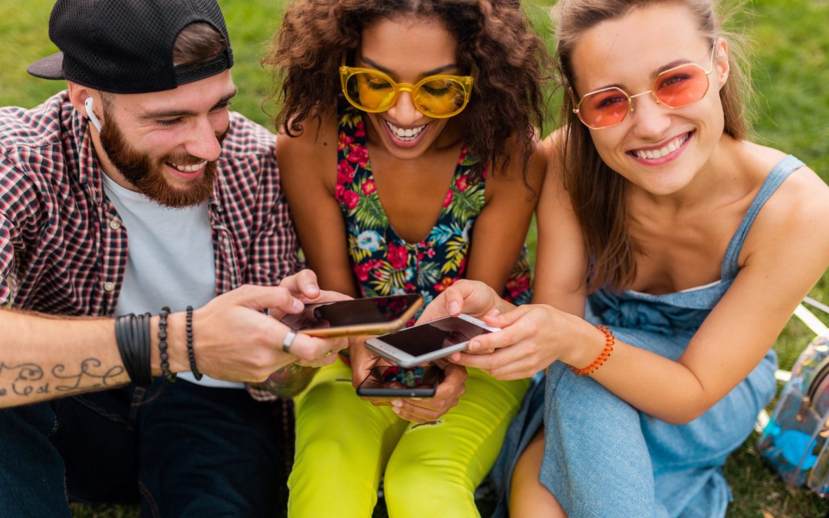 Group of teenagers having fun exchanging clothes and accessories through the Upswap app.