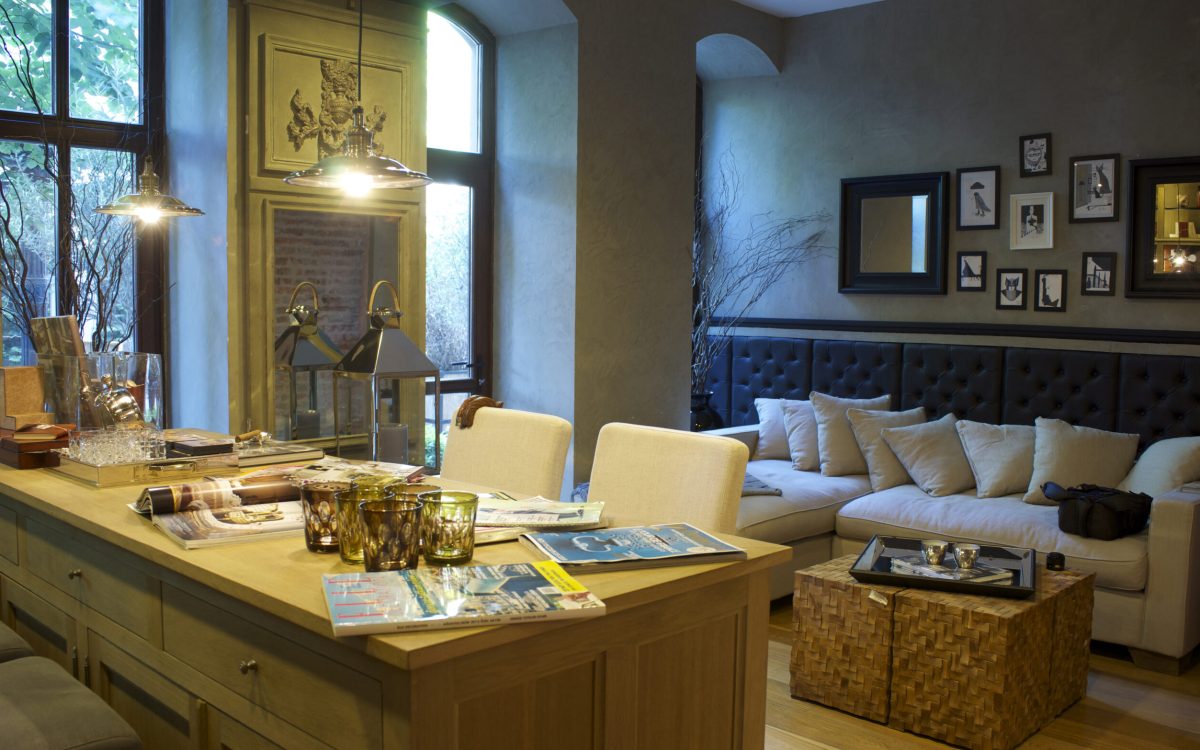 A cozy living room decorated with colorful Indian textiles, metallic lamps, and a large mirror.