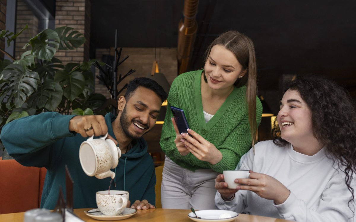 Group of friends laughing and chatting over chai cups