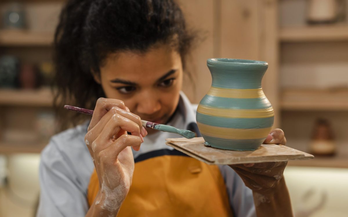 Indian girl painting on a clay pot