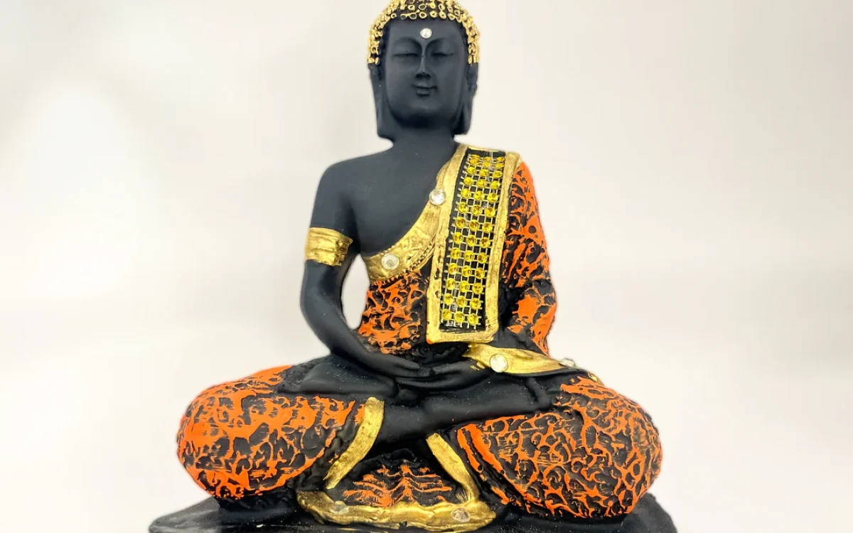 Introducing the "Lord Buddha Sitting Statue," a stunning piece of art crafted from durable polyresin and finished in an elegant black and orange color scheme.